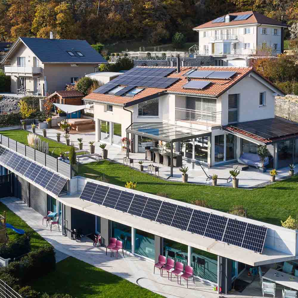 Villa avec jardin et terrasse équipée de solutions photovoltaïques par Flückiger, énergie durable mise en avant.