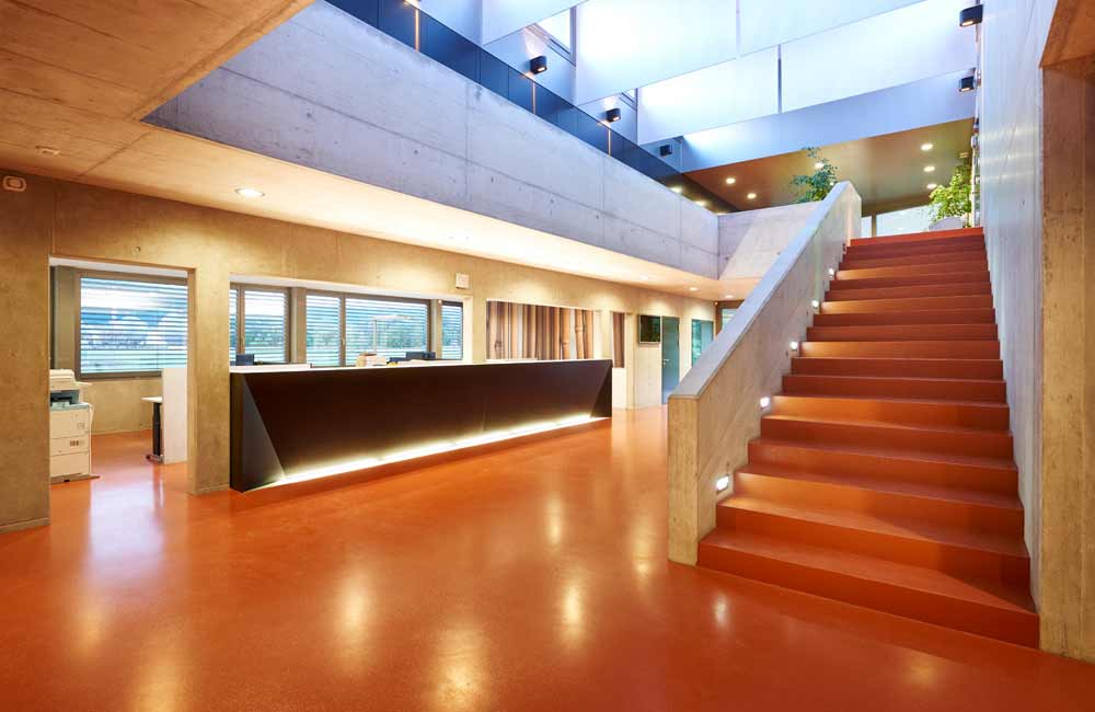 Intérieur de locaux industriels avec un concept d'éclairage épuré et performant, illustrant l'expertise de Flückiger en éclairage pour espaces de travail.