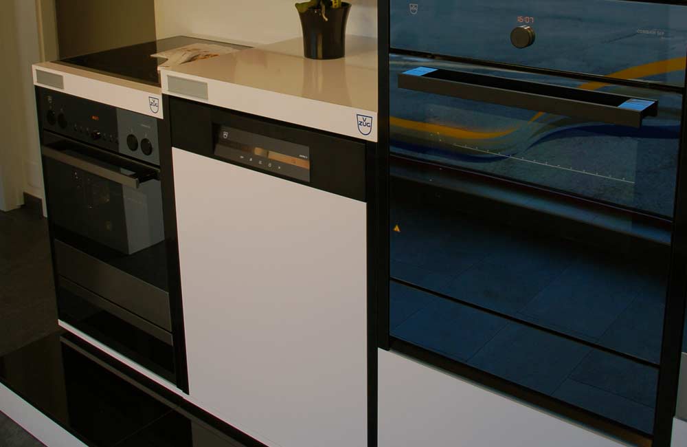 Cuisine moderne équipée d'un four, d'un réfrigérateur et de plaques vitrocéramiques très modernes, reflétant l'intégration des dernières technologies d'appareils chez Flückiger.