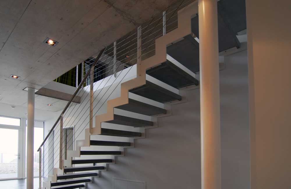 Cage d'escalier avec éclairage encastré, soulignant l'attention de Flückiger aux détails architecturaux et à l'éclairage fonctionnel.